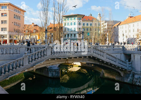 Ljubljana, Slowenien - 14 Januar, 2019: Drei Brücken über dem Fluss Ljubljanica Altstadt Straße in Ljubljana, Slowenien. Schönen slowenischen Hauptstadt grüne Stadt. Brücke Tromostovje bei Preseren Platz. Stockfoto