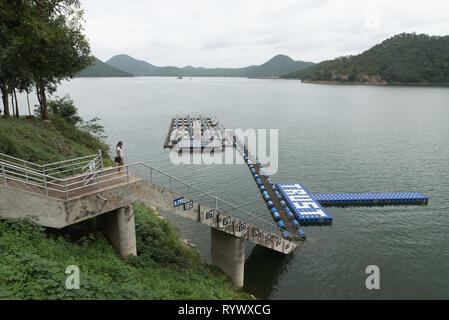 Frau, die an der Spitze der Treppe auf resevoir Suchen am See Stockfoto