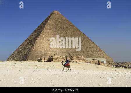 Camel Riders im Vordergrund und der Großen Pyramide von Ägypten in den Hintergrund, die Pyramide von Gizeh, Kairo, Ägypten Stockfoto