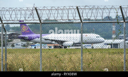 Phuket, Thailand - 23.April 2018. Zaun mit Stacheldraht um Flughafen mit einer Dockingstation Flugzeug in Phuket International Airport (HKT). Stockfoto