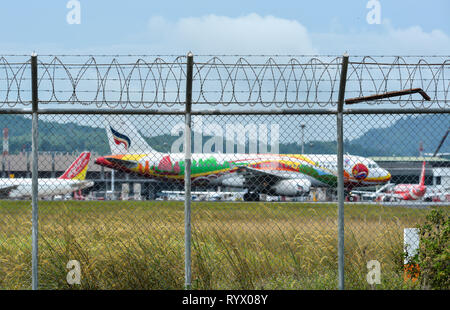 Phuket, Thailand - 23.April 2018. Zaun mit Stacheldraht um Flughafen mit einer Dockingstation Flugzeug in Phuket International Airport (HKT). Stockfoto