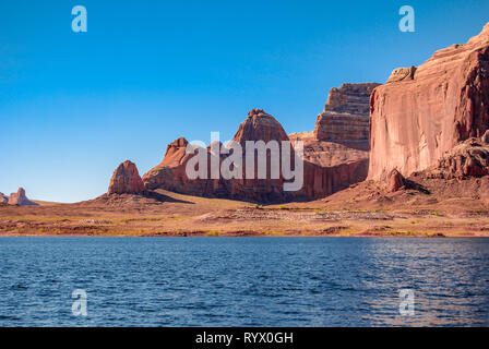 Ein warmer Sommer am Nachmittag am Lake Powell, Utah. Große rote, orange Sandstein Felsen und Klippen framing das Tiefblaue Wasser wie ein Schwimmbad. Stockfoto