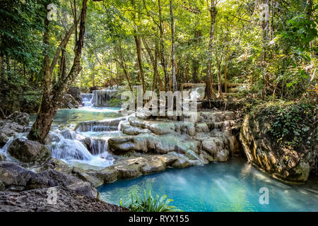 Glatte Felsen mit Cascading Wasser eine Reihe von schönen kurzen Wasserfälle in den dichten Wald von Erawan Nationalpark in Thailand Aussehen inszeniert Stockfoto