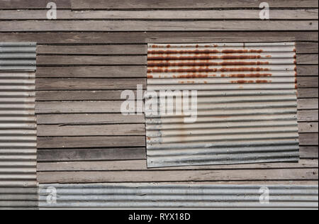 Windows auf rustikalen verlassenen Haus in Wellblech abgedeckt Stockfoto