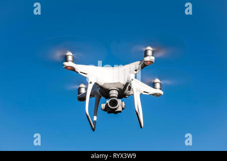 Vorderansicht des DJI Phantom 4 PRO quadcopter Drohne fliegen am blauen Himmel, Neidlingen, Deutschland Stockfoto