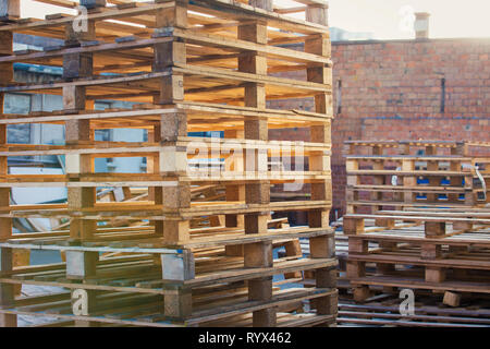 Im freien Hintergrund der Lager Holz- versand Paletten übereinander für industrielle Transport recycling Depot gestapelt. Stapel von Euro Stockfoto