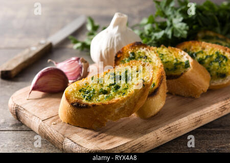 Brot in Scheiben schneiden und Knoblauch Zutaten auf Holztisch. Stockfoto