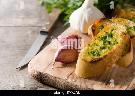 Brot in Scheiben schneiden und Knoblauch Zutaten auf Holztisch. Copyspace Stockfoto