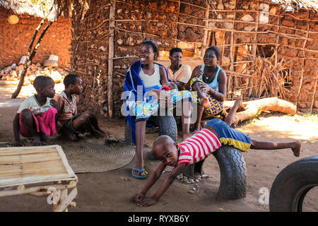 Malindi, Kenia - April 06, 2015: Lokale Frauen mit ihren Kindern vor Ihrer provisorischen Haus saß. Trotz der schlechten Lebensbedingungen, Menschen sind Stockfoto