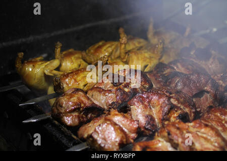 Schweinefleisch und Wachteln Grill am Spieß braten auf einem Grill Brazier Stockfoto