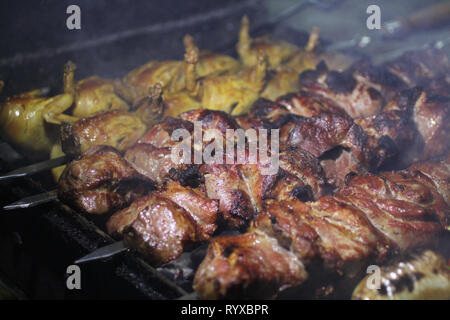 Schweinefleisch und Wachteln Grill am Spieß braten auf einem Grill Brazier Stockfoto