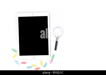 Arbeitsbereich Draufsicht der Tablette, Lupe auf einem weißen Schreibtisch im Büro Konzept plaziert ist Stockfoto