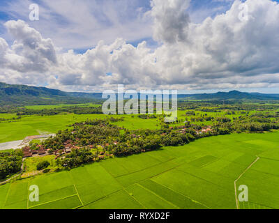 Spektakuläre Landschaft mit dramatischen Wolken und Himmel. Fruchtbare Rohreis Felder mit lebendiger Farbe und Dörfer. Stockfoto