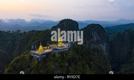 Ansicht von oben, atemberaubenden Blick auf die wunderschöne Tiger Cave Tempel (Wat Tham Sua) durch erstaunliche Bergrücken von Kalkstein Bergen umgeben. Stockfoto