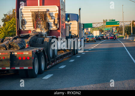 Mächtigen amerikanischen Big Rig gängigen professionellen Long Haul classic Semi Truck ein weiterer Big Rig semi Traktor Transport befestigt auf Schritt nach unten halb Trail Stockfoto