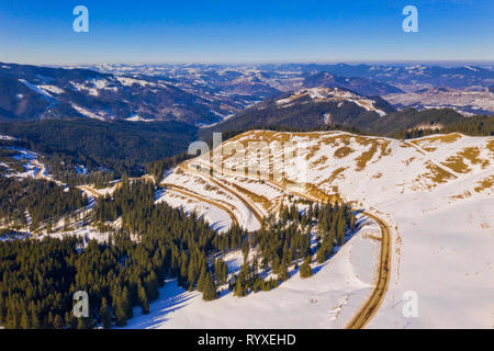 Winter kurvige Straße in das Rarau-massiv, Antenne Szene in den rumänischen Karpaten. Stockfoto