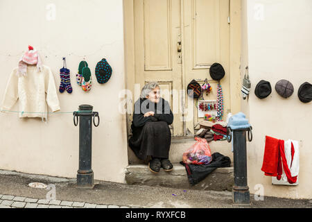 Signagi, Georgien - November 23, 2011: Lokale Frau verkaufen Handgemachte wolle Produkte als Souvenir auf einer Straße in Signagi, Georgien Stockfoto
