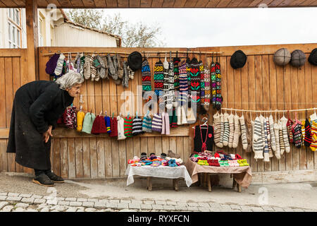 Signagi, Georgien - November 23, 2011: Lokale Frau verkaufen Handgemachte wolle Produkte als Souvenir auf einer Straße in Signagi, Georgien Stockfoto