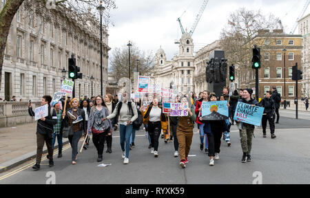 London, Großbritannien. 15 Mär, 2019. Streik Gruppe von Jugendlichen marschieren mit Fahnen und Flaggen für den Klimawandel außerhalb der Downing Street. Credit: AndKa/Alamy leben Nachrichten Stockfoto