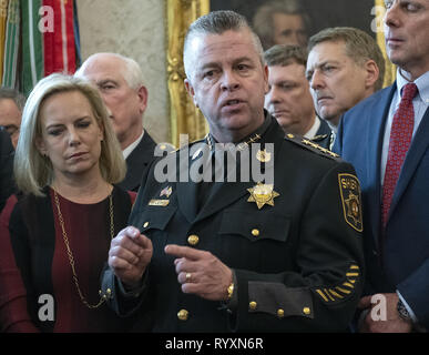 Washington, District of Columbia, USA. 15 Mär, 2019. Polizeichef Michael A. Lewis von Wicomico County, Maryland macht eine Aussage vor dem Präsidenten der Vereinigten Staaten Donald J. Trumpf die Unterzeichnung der Veto Erklärung der vom Kongress verabschiedet, um die nationalen Notstands, die er früher erklärt die lange verzögerte südliche Grenze Mauer im Oval Office des Weißen Hauses in Washington, DC am Freitag zu finanzieren, Block, 15. März 2019. US-Heimatschutzministerium (DHS) Kirstjen Nielsen sieht von links Credit: Ron Sachs/CNP/ZUMA Draht/Alamy leben Nachrichten Stockfoto