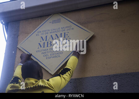 Madrid, Spanien. 15 Mär, 2019. Demonstrator sticks die Plakette in den Speicher von Mame Mbaye. Protest gegen institutionellen Rassismus am Nelson Mandela Square ein Jahr nach dem Tod von Mame Mbaye, einem senegalesischen Straßenverkäufer, starb, während er von der Polizei für den Verkauf auf der Straße gejagt werden. Nach Angaben der Demonstranten, der junge Mann hatte keine legalen Papiere trotz mehr als 10 Jahre in Spanien verbracht und Behörden hat seine Familie nicht nach seinem Tod. Credit: Lito Lizana/SOPA Images/ZUMA Draht/Alamy leben Nachrichten Stockfoto