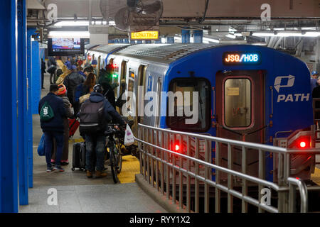 Personen, die an Bord eines Journal Square/Hoboken-U-Bahn-Zuges in Richtung NY/NJ PATH fahren Am Herald Square Stockfoto