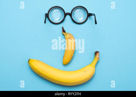 Gelbe Banane und lustig Kreis glaases in von der lachende Happy Face Stockfoto