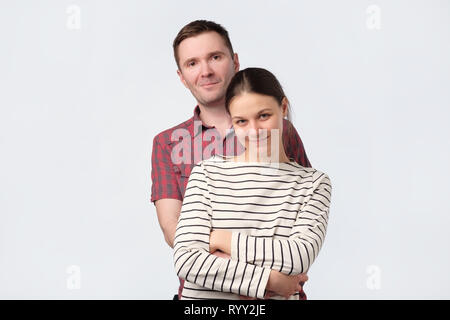 Junge europäische Paar stehend gegen Weiß grauer Hintergrund Stockfoto