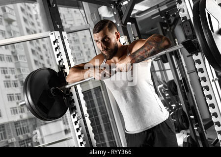 Bodybuilding. Bärtiger Mann stehend auf Barbell im Fitnessstudio auf der Suche nach vorne sassy Stockfoto