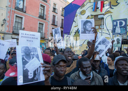 Demonstranten mit dem Portrait von Mame Mbaye während des Protestes gesehen. Protest gegen institutionellen Rassismus fand am Nelson Mandela Square in Madrid ein Jahr nach dem Tod von Mame Mbaye, einem senegalesischen Straßenverkäufer, starb, während er von der Polizei für den Verkauf auf der Straße gejagt werden. Nach Angaben der Demonstranten, der junge Mann hatte keine legalen Papiere trotz mehr als 10 Jahre in Spanien verbracht und Behörden hat seine Familie nicht nach seinem Tod. Sie bezahlten auch Hommage an die Opfer des New Zeland Terroranschlag in Moscheen. Stockfoto