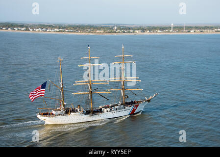 Coast Guard Cutter Eagle Transite auf der Savannah River in Richtung Savannah, Georgia, 15.03.2019, vor der Tybee Island Lighthouse. Der Adler kam in der Savanne für St. Patrick's Day Wochenende mit über 100 Gästen an Bord. (U.S. Coast Guard Foto von Petty Officer 3. Klasse Ryan Dickinson) Stockfoto