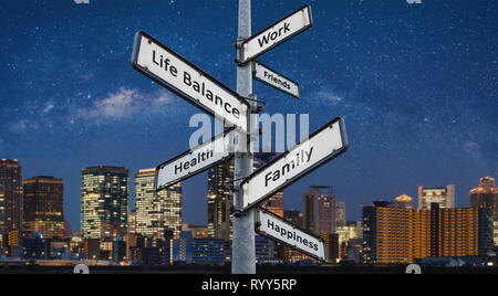 Life Balance Wahlen auf Wegweiser, Stadt bei Nacht Hintergründe Stockfoto
