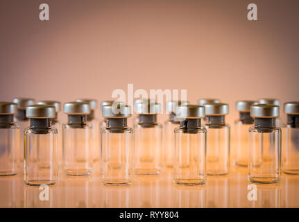 Gruppe von Impfstoff Glasflaschen auf orange Hintergrund Stockfoto