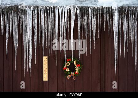 Schöne Eiszapfen hängen vom Haus Dach im Winter. Konzept für Winter und Frost. Stockfoto