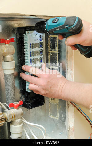 Die Hände des Menschen zur Festsetzung eines Schalters für Thermostate und Servo Antriebe Ventile in einem Haus Heizung. Stockfoto