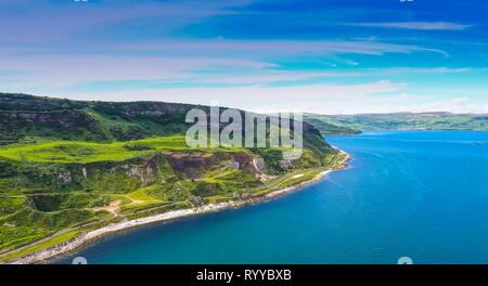 Erstaunlich Luftaufnahme des blauen Meer und Berg in Cushendun die schöne Landschaft Ansicht der grünlich Berg mit der kleinen Straße fronting Stockfoto