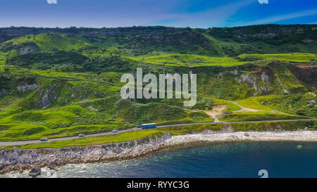 Luftaufnahme des schönen Berg in Cushendun Irland Es ist ein langer Weg, auf dem Berg Seite mit einem Bus und Pkw in Irland reisen Stockfoto