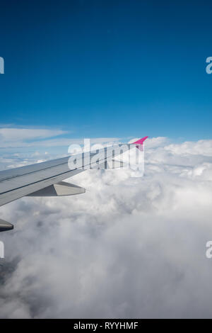 Luton, England - September 2018: Fenster mit Blick auf den Flügel eines Flugzeugs fliegen über den Wolken Stockfoto