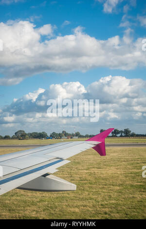 Luton, England - September 2018: Fenster mit Blick auf einen Flügel eines Flugzeugs während der Landung auf dem Flughafen Stockfoto