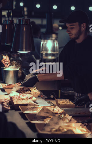 London, England - November 2018: Männer mit Take away Home Main Mahlzeiten auf der Street Food Markt Stockfoto