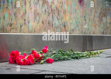 London, England - Dezember 2018: Blumen unter Graffiti im Gedächtnis von Sänger David Bowie links als Ziggy Stardust, Brixton Stockfoto