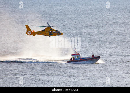 Ein Helikopter der Niederländischen coastgard ist Abseilen ein Mann über dem Meer während einer Rettung bohren Stockfoto