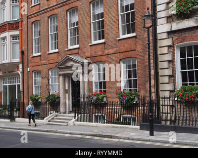 London Gebäudefassaden in der Nähe von Mayfair, mit floralen Blumenkästen Stockfoto