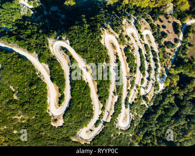Luftbild von Oben nach Unten Blick auf Serpentine schmale Straße nach Vikos Schlucht im Norden Griechenlands. Ein Weg voller Drehungen und Wendungen stark Liquidation den Berg Stockfoto