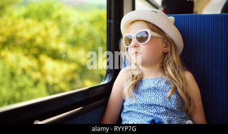 Junges Mädchen mit dem Zug reisen im Sommer Tag niedlich. Kind sitzen durch das Fenster der Waggon und außerhalb. Zicklein auf Familienurlaub in Europa. Stockfoto