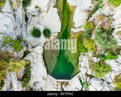 Luftbild von Oben nach Unten Blick auf Papingo Rock Pools, auch genannt Ovires, natürlichen, grünen Wasser Pools in kleinen Glattwandigen Schlucht in der Nähe des Dorfes Pap entfernt Stockfoto