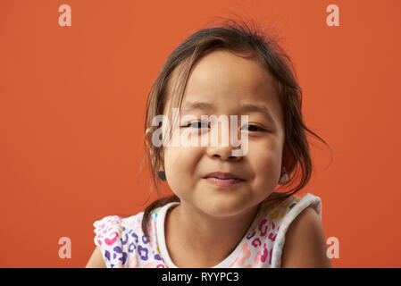 Portrait von schweren asiatischen Mädchen auf orange Farbe Hintergrund isoliert Stockfoto