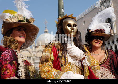 Die Menschen gekleidet in traditionelle Maske und Kostüm für Karneval in Venedig stehen an der Piazza San Marco, Venedig, Venetien, Italien Stockfoto