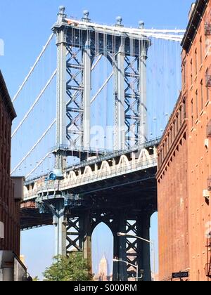 Die Manhattan Bridge, das Empire State Building einrahmen, wie aus der DUMBO Nachbarschaft von Brooklyn, New York zu sehen. Stockfoto