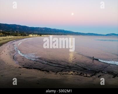 Die Sonnenuntergänge wie der Mond aufgeht über der letzten Surf-Session des Tages, Santa Barbara, Kalifornien Stockfoto